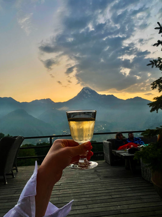 A traditional glass of Georgian wine with Georgian mountains on the background