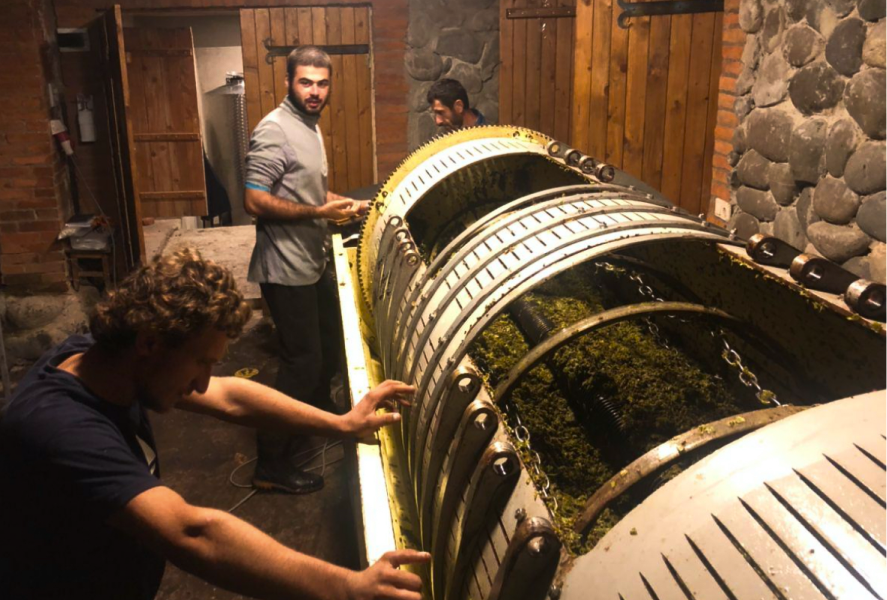 Team members at Baias Wines working with winemaking equipment in the winery