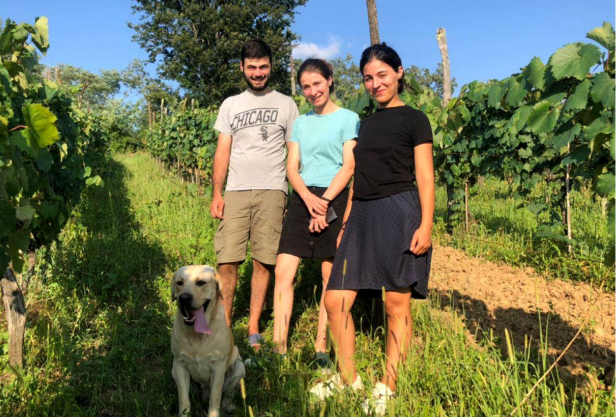 Founders of Baias Wines standing together in a vineyard with their dog