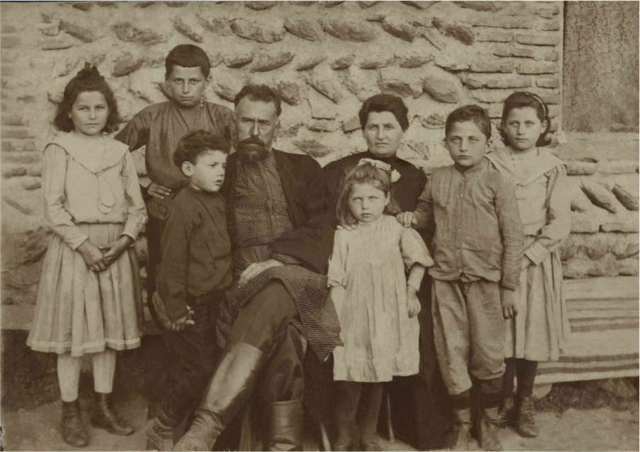 Family of the founders of Wine Man Winery, posing together in front of a stone wall